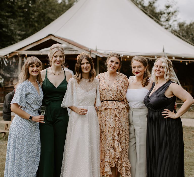 Bride stands with her wedding guests on her wedding day outdoors