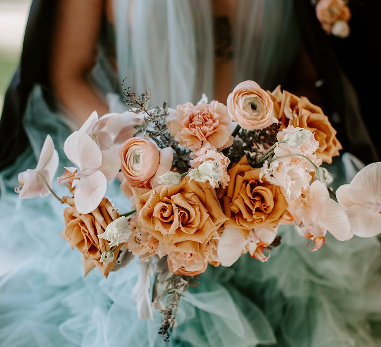 Cafe au late, peach and pink wedding bouquet with roses, ranunculus, carnations and orchids.