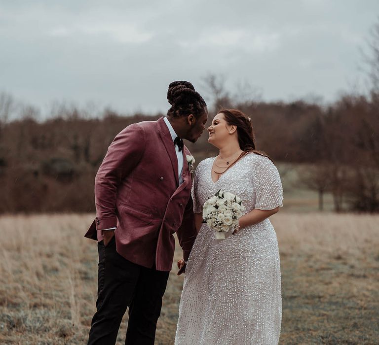 Bride & groom kiss on their wedding day outside 