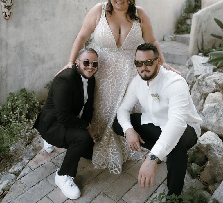 Bride in v-neck wedding dress standing with wedding guests in sunglasses for destination wedding in Barcelona 