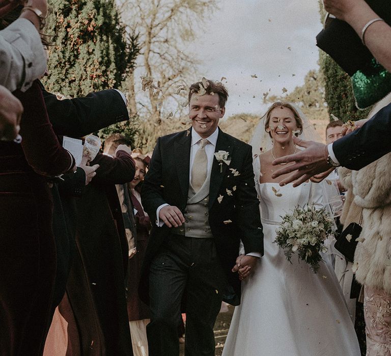 Bride and groom amidst confetti at Hedsor House wedding