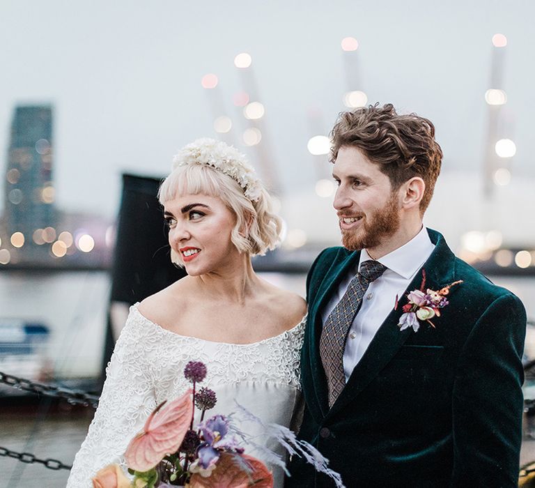 Bride and groom smile as they look over views of Millennium Dome and London