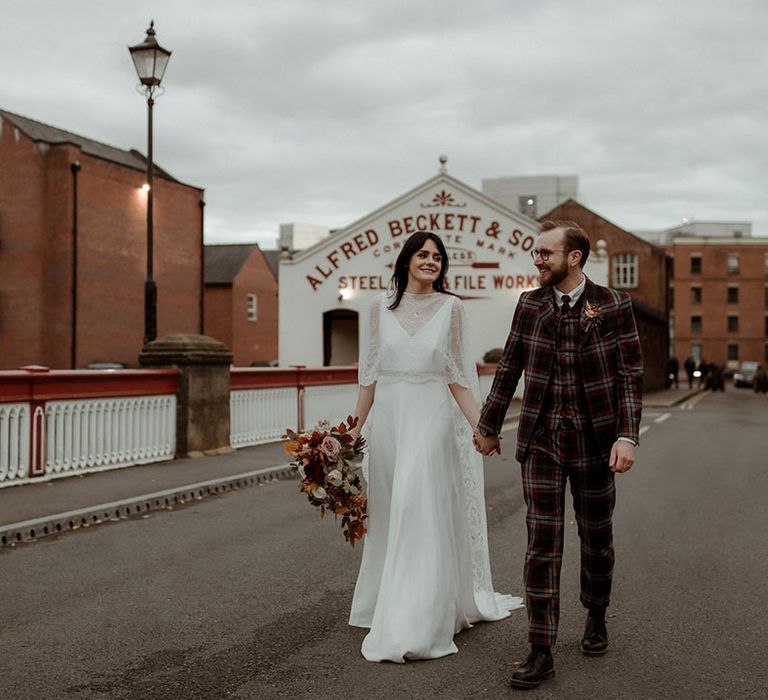 Bride & groom walk down road on their wedding day 