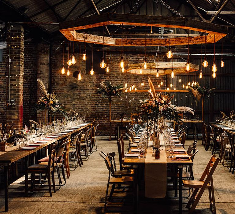 Boho and industrial style wedding reception with dried flowers, festoon lighting and exposed brick 