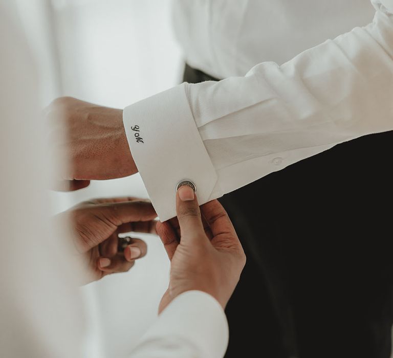 Groom wears white shirt with personalised embroidery to the cuff 