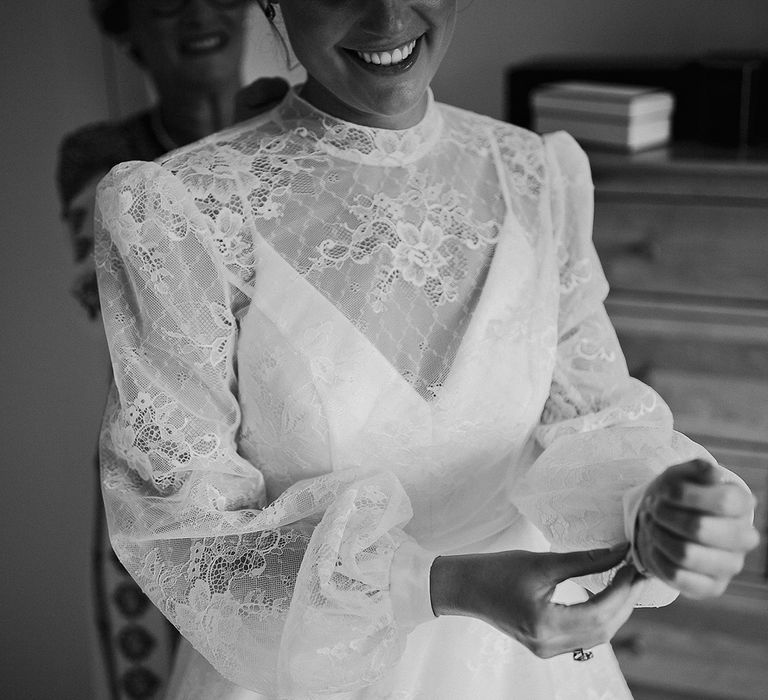 Bride in a Sassi Holford high neck long sleeve lace wedding dress getting ready for the day 