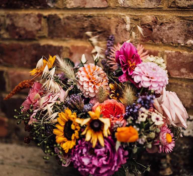 Colourful and bright wedding bouquet with dahlias, roses and sunflowers