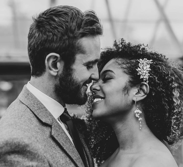 Bride with pearl and gold jewellery and accessories with the groom in a grey suit 