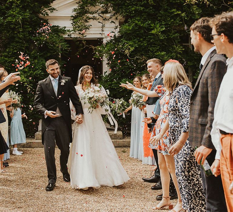 Bride and groom have a confetti exit after their wedding ceremony 