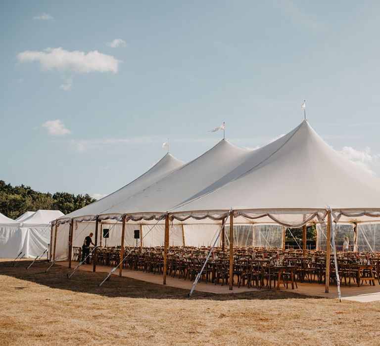 Sailcloth tent complete with banquet tables for black-tie wedding reception