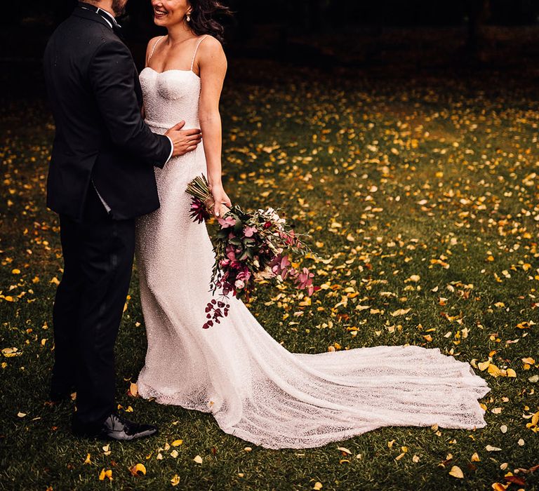 Gorgeous bride in a fitted beaded sparkle wedding dress from Made With Love smiling at the groom in black tie