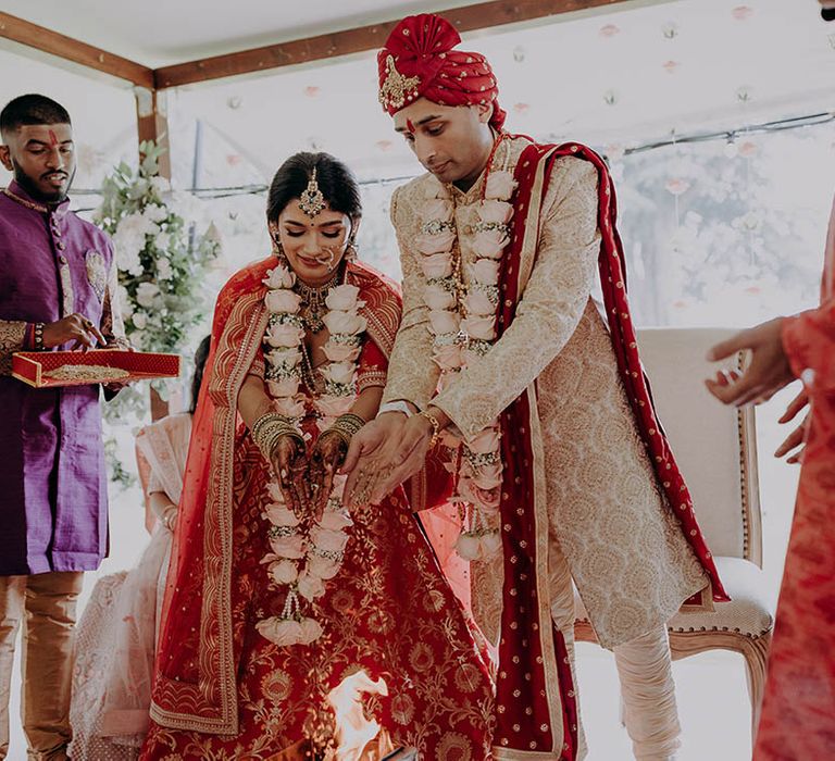 Bride & groom take part in Hindu wedding traditions during wedding ceremony 