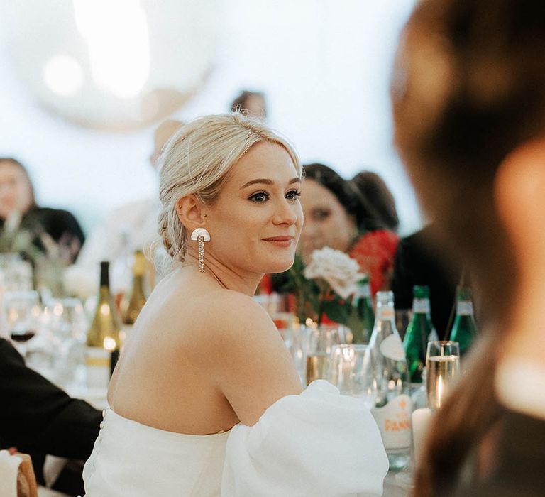 Blonde bride wears statement earrings and puffed sleeve Jesus Peiro wedding dress 