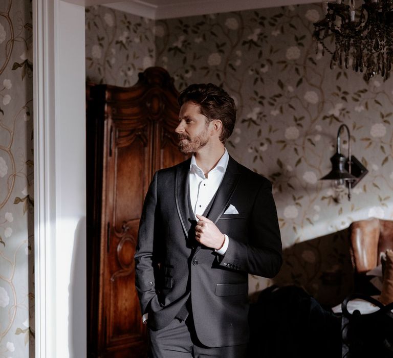 Groom in classic black blazer and suit trousers with white shirt and white pocket square 