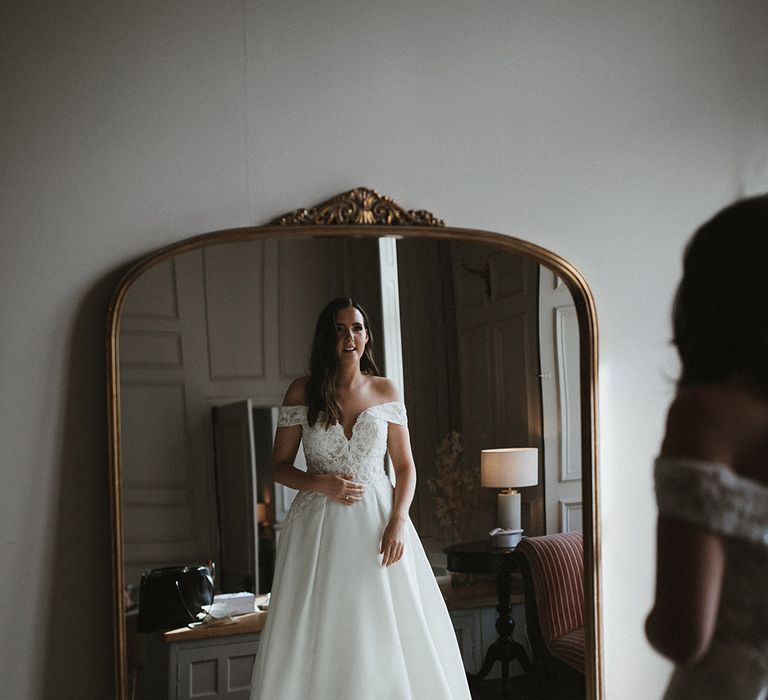 Bride in off the shoulder lace and princess skit wedding dress from Pronovias with her hair in soft waves 