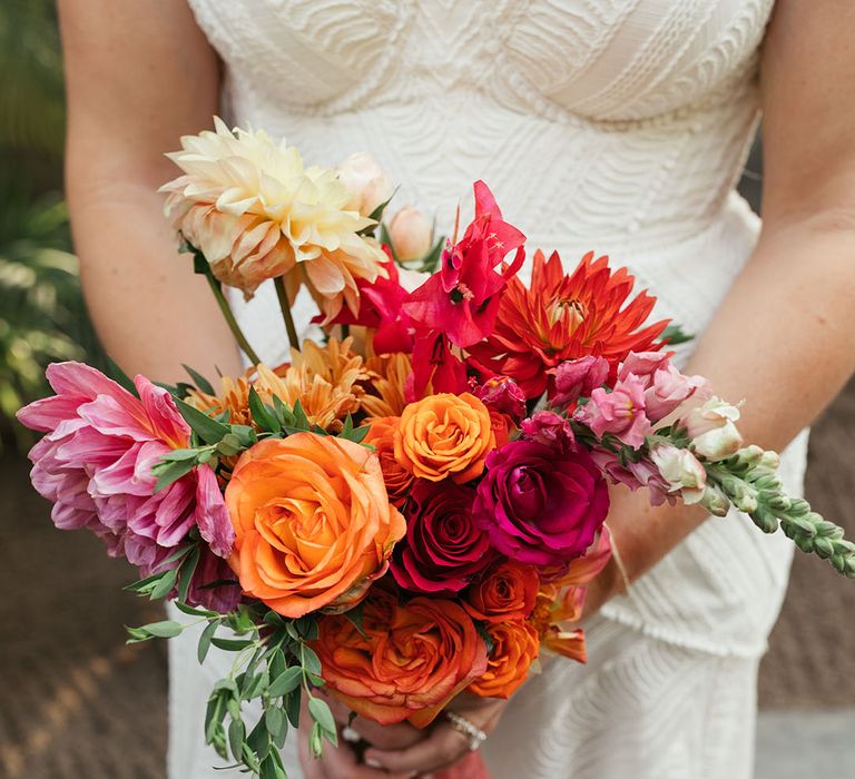 Bride holds vibrant and tropical floral bouquet 