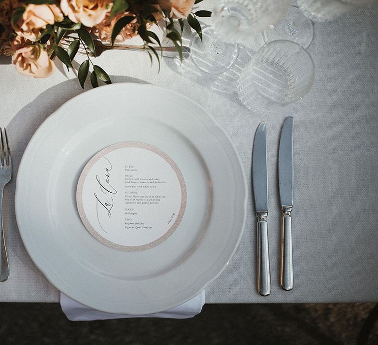 Classic tablescape with white plates and simple round menu 