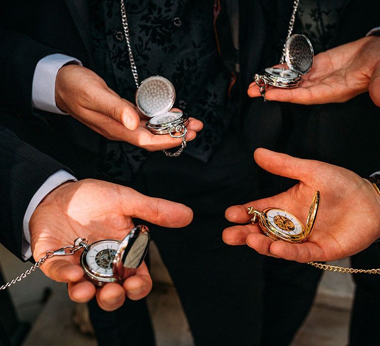 The groom and groomsmen holding matching silver pocket watches groom accessories 