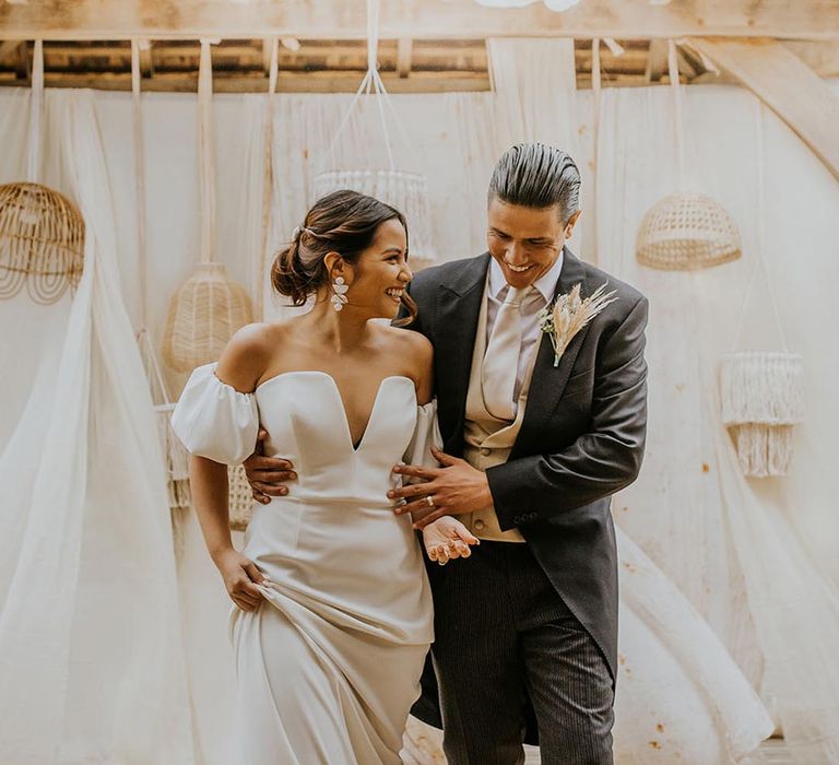 The Canary Shed boho wedding with wool rugs and drape decor and bride in a strapless wedding dress and groom in a classic morning suit