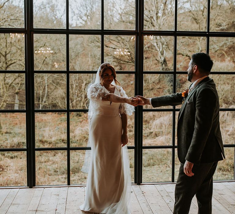 Bride in a Suzanne Neville wedding dress dancing with the groom at their Hidden River Barn wedding 