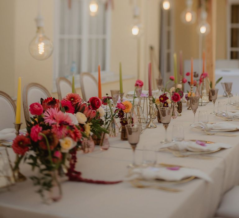 wedding table decorations with flower centrepieces and coloured candles 