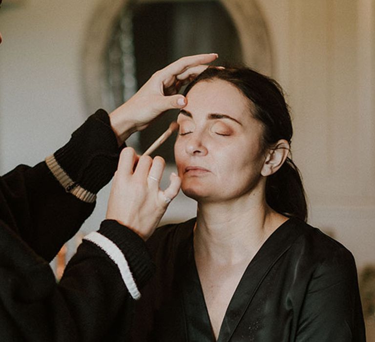 The bridesmaid gets her makeup done for the wedding day at Larkspur Lodge in Cheshire 