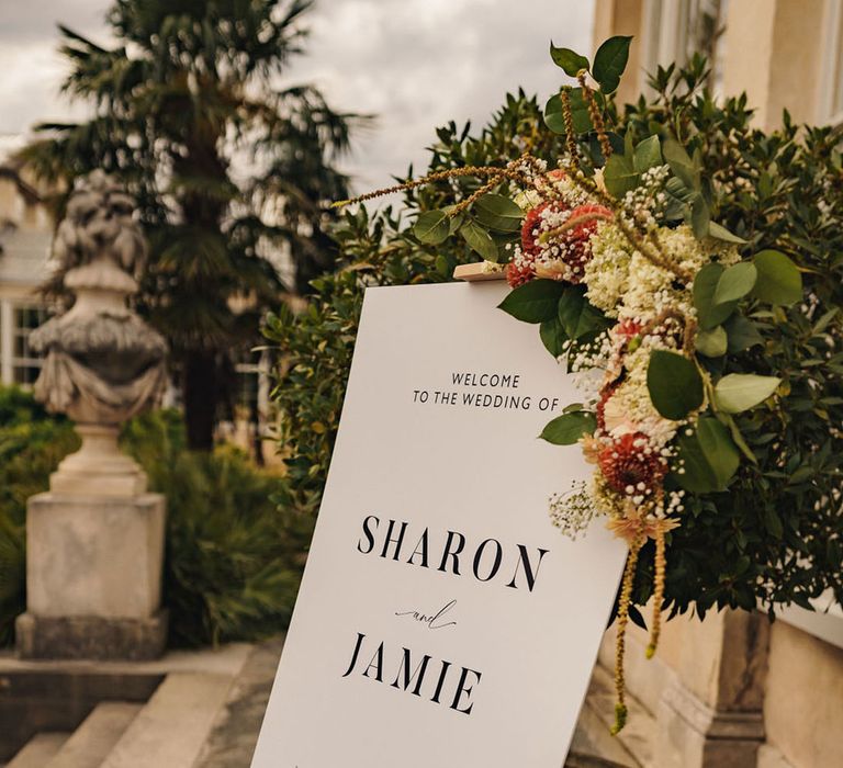 Black and white minimalist wedding welcome sign decorated with flowers 