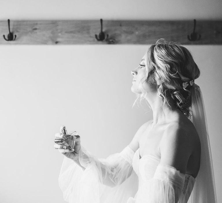 Bride spraying wedding perfume on her wedding morning