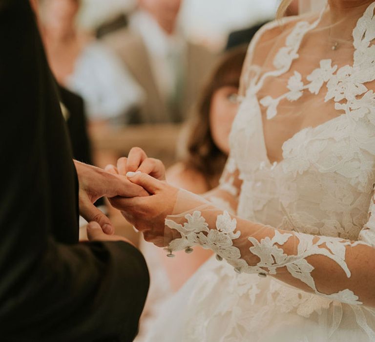 The bride and groom exchange rings for their wedding ceremony 