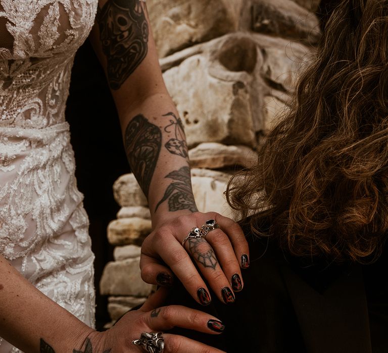 Bride with red and black wedding nails with nail art that spells out her new last name 