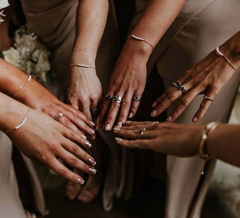 Bridesmaids and bride all wearing matching pearl and gold bracelets for the wedding 