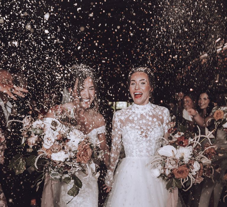 Fun confetti moment at their same sex wedding with flower wedding dresses for romantic 