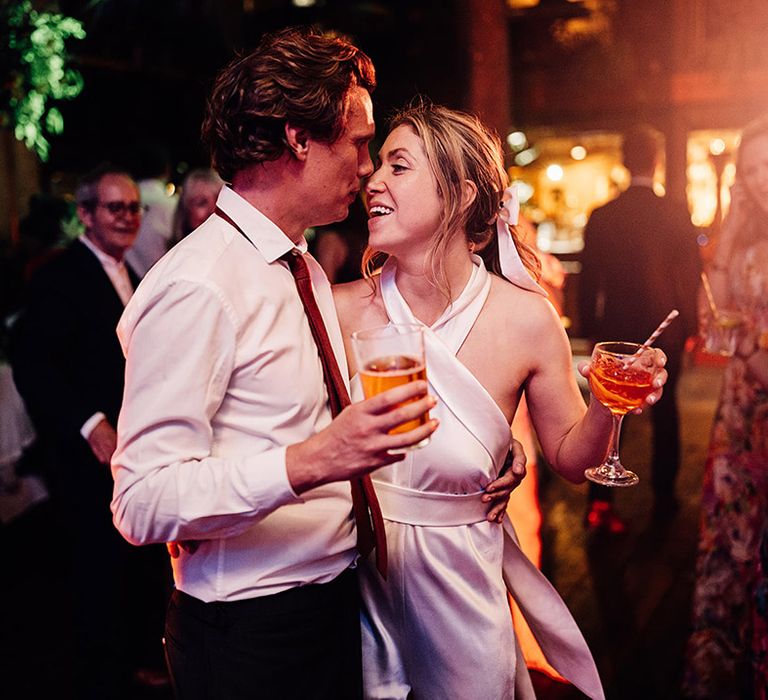 Bride in halterneck wedding reception dress dancing with groom 