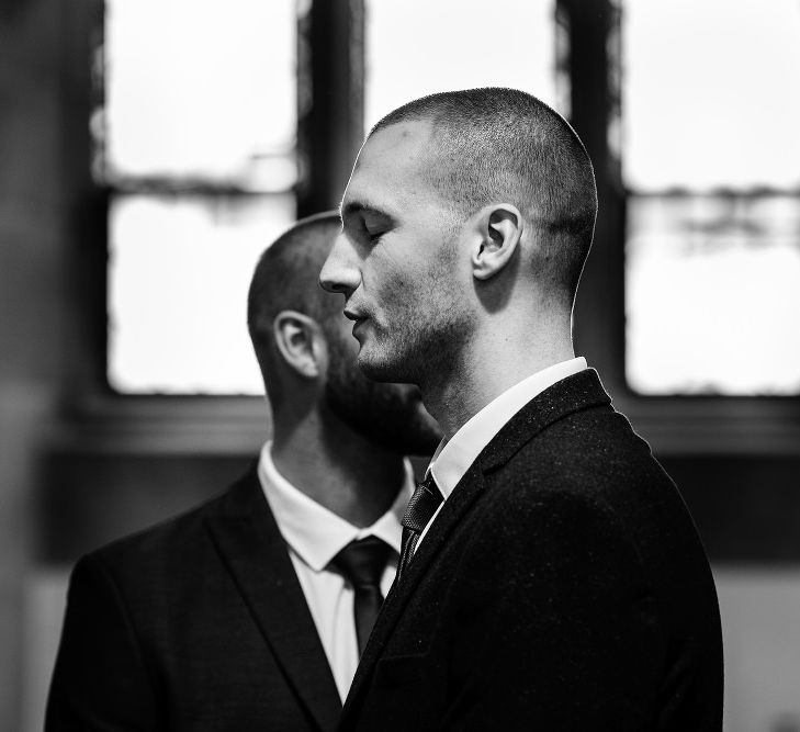 Black and white portrait of the groom at the altar 