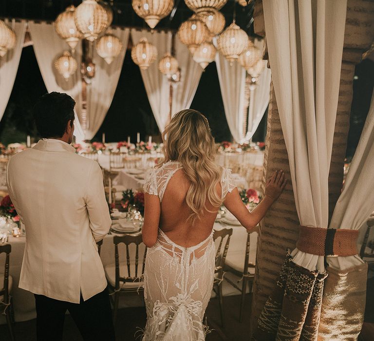 Bride and groom entering the wedding reception with Moroccan lantern wedding decor 