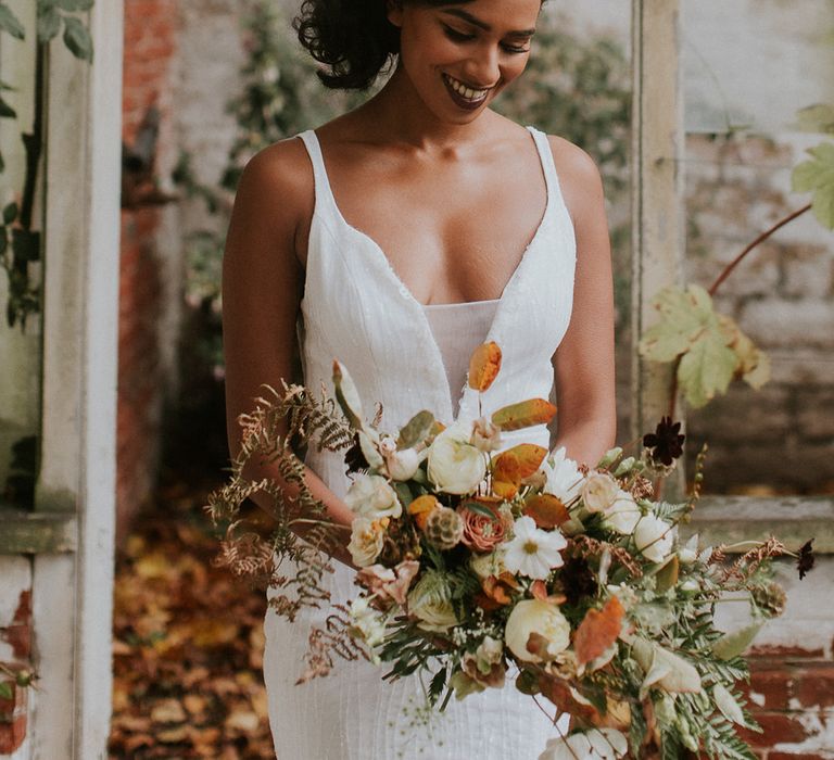 Beautiful bride with autumn floral headdress and wedding bouquet 