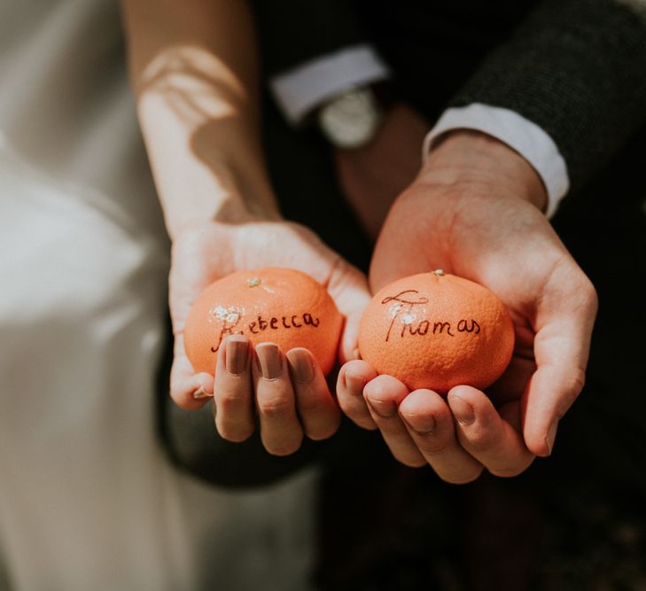 Bride and groom holding an orange 