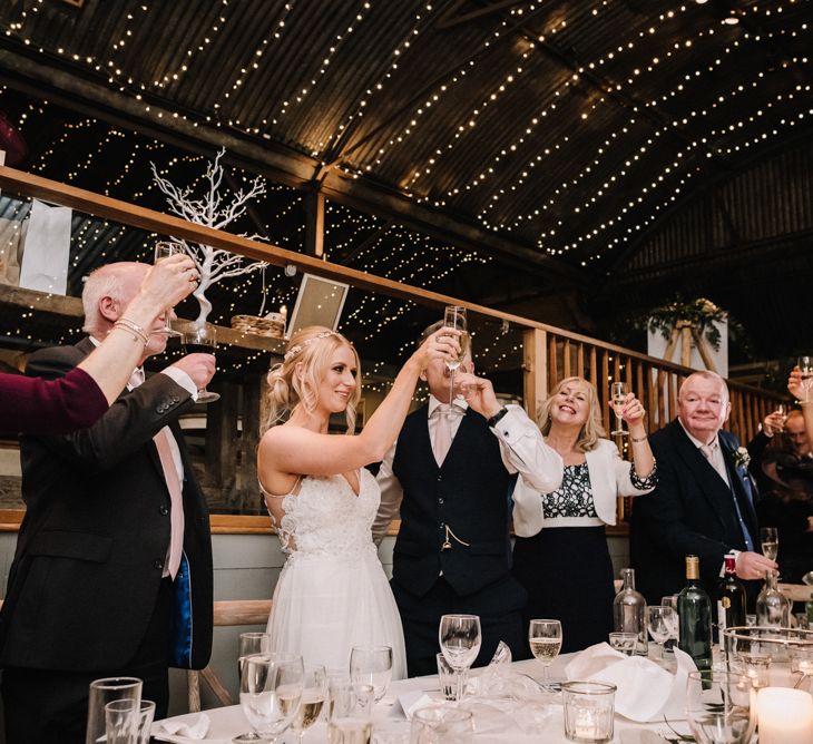 Wedding party raising a toast at rustic classical barn wedding 