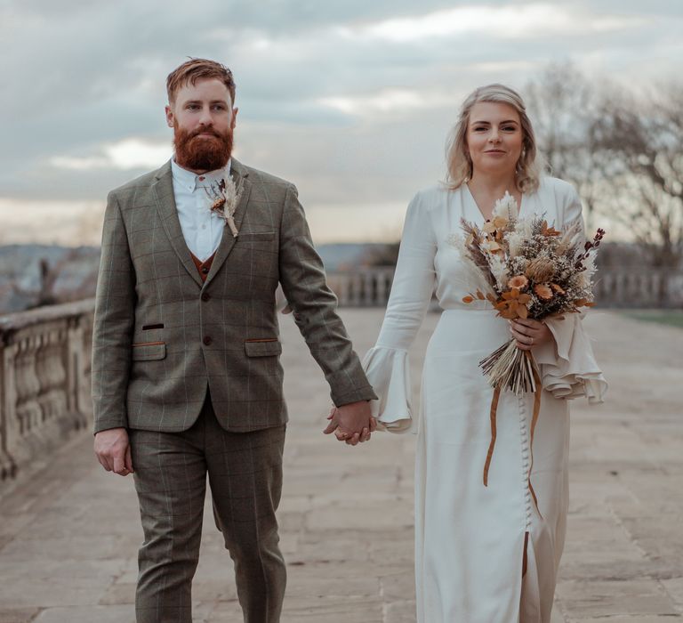 Bride & groom pose at Cliveden House on wintery day