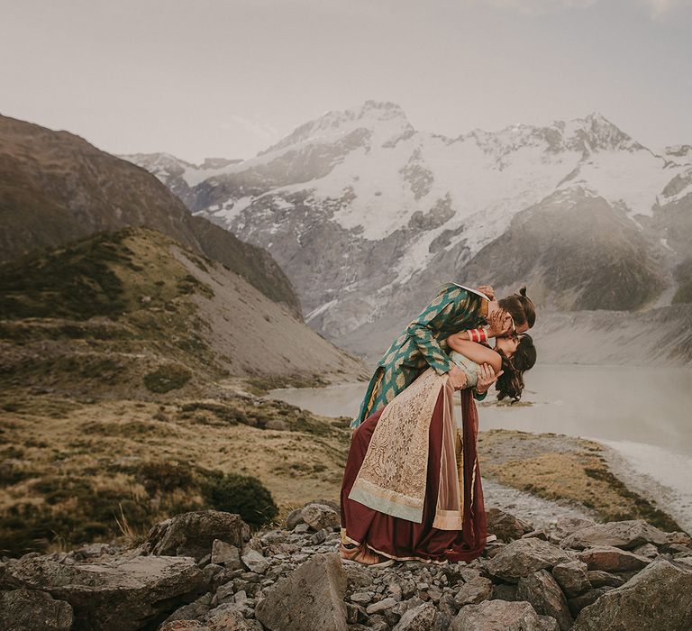 The groom dips the bride on top of Mount Cook in New Zealand