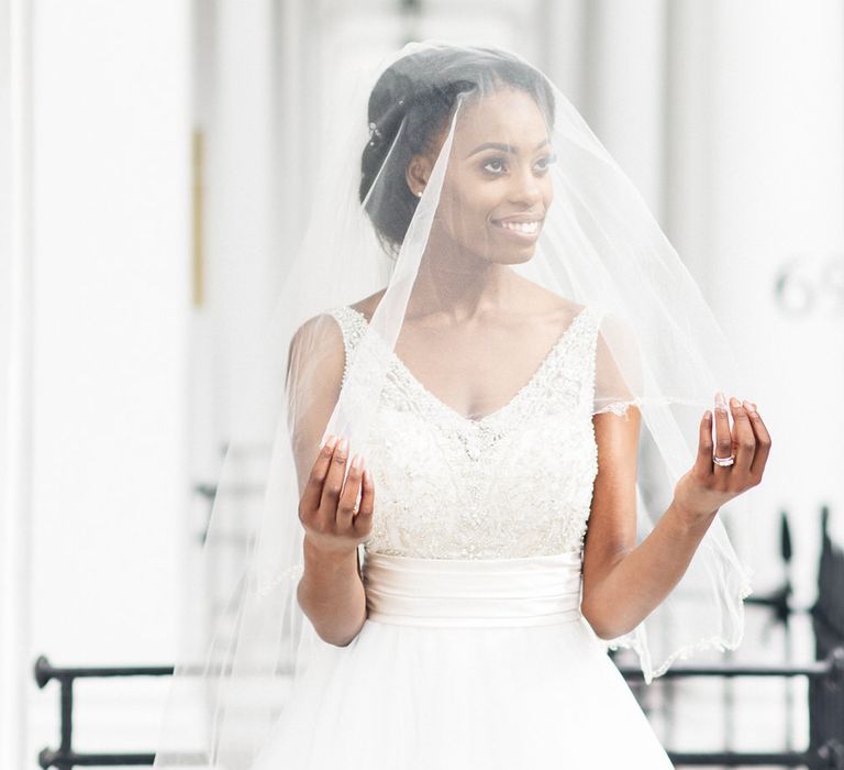 Bride has veil over her head outdoors in London