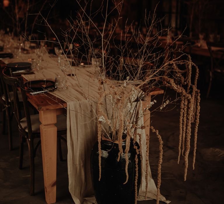 Minimalist dried flower arrangements in vases at the end of the reception tables 