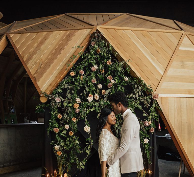 Aisle and altar decor with candles in bottles, black sheet and pink and green wedding flowers 