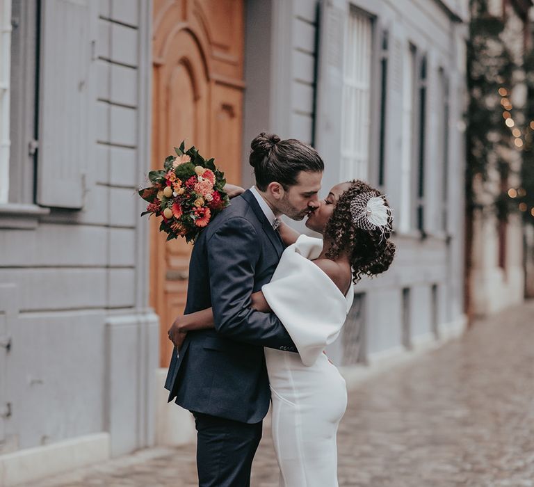 Bride & groom kiss on the street 