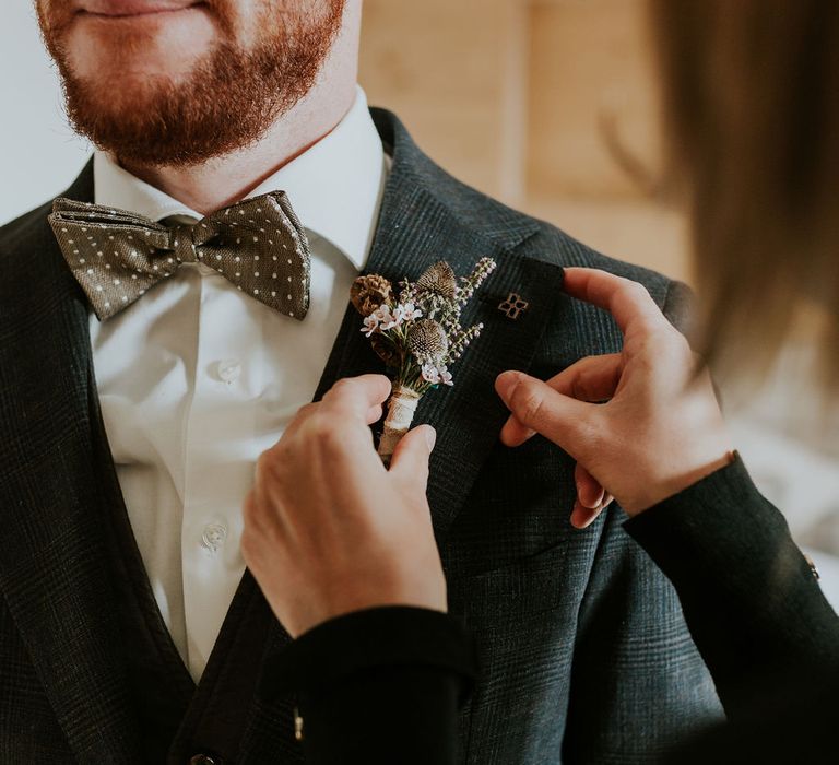 Dried and fresh flower buttonhole and polka dot bow tie for the groom 