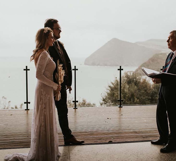 Intimate seaside elopement in Devon with views of the beach during the wedding ceremony 