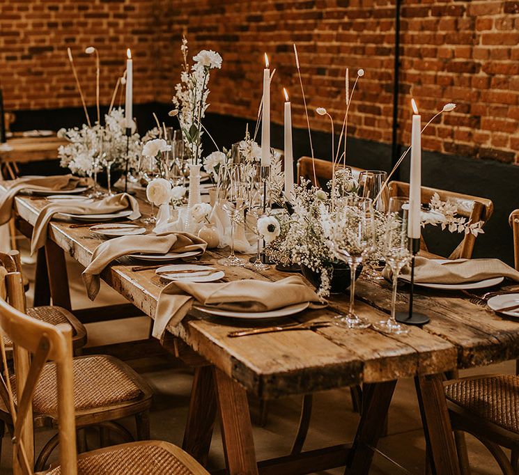 Neutral and white wedding table decor with taper candles and dried flowers