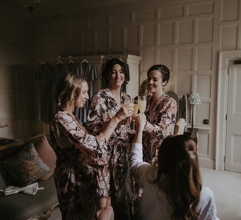 Bridesmaids get ready on the morning of wedding as they wear matching floral dressing gowns