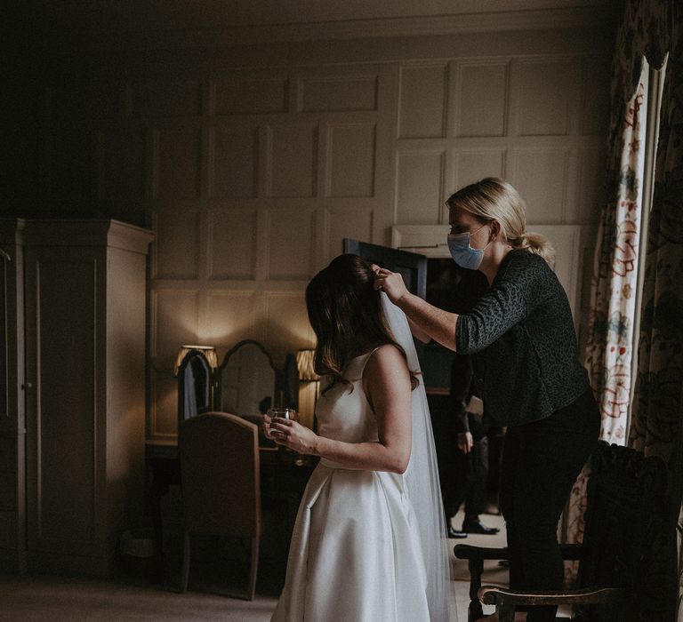 Bride has her veil applied on the day of her wedding