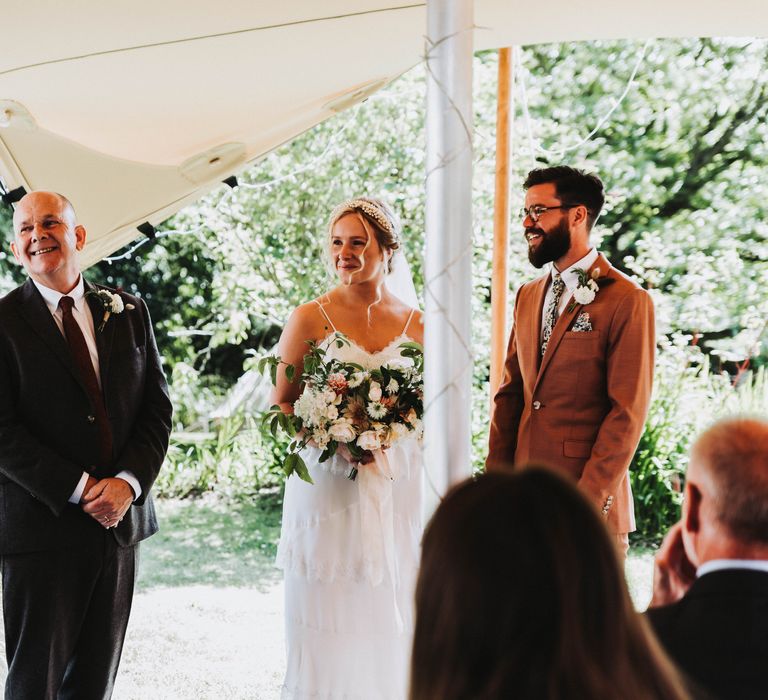 Bride & groom look toward brides father on wedding day